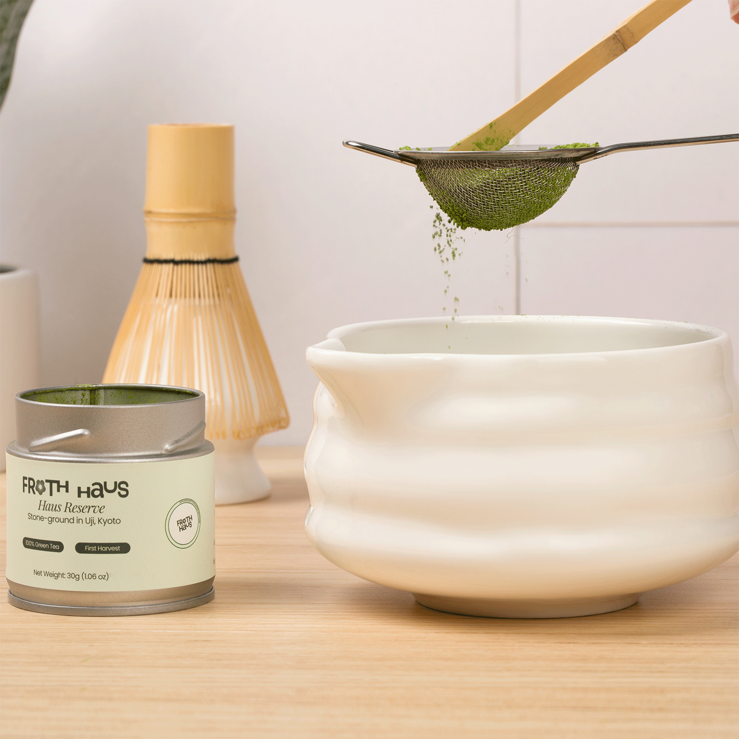 Haus Reserve Matcha being prepared with a bamboo matcha whisk